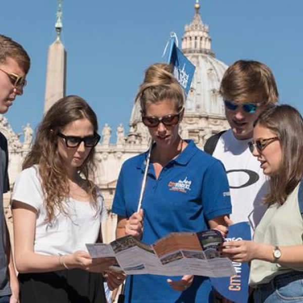 Guida con alcuni visitatori all'esterno dei Musei Vaticani a Roma